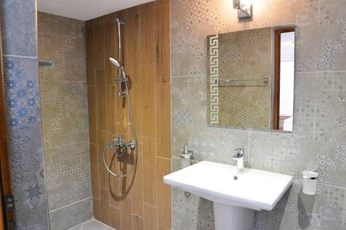 a bathroom with a sink and a shower with a mirror at Villa Rila Garden in Beli Iskar