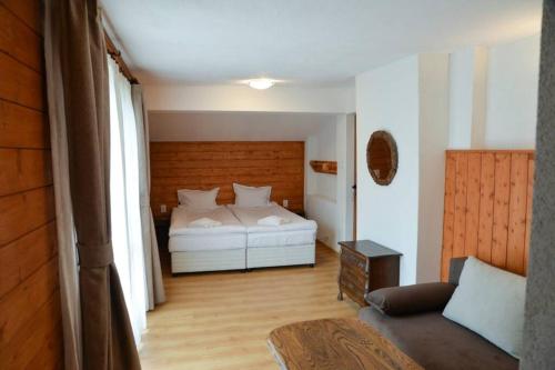 ein Schlafzimmer mit einem Bett und einem Sofa in einem Zimmer in der Unterkunft Villa Rila Garden in Beli Iskar