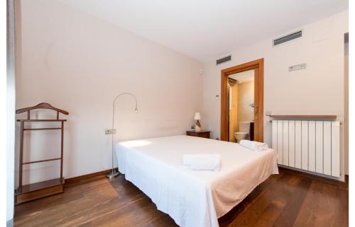 a bedroom with a large white bed in a room at HomeHolidaysRentals Royal in Pineda de Mar