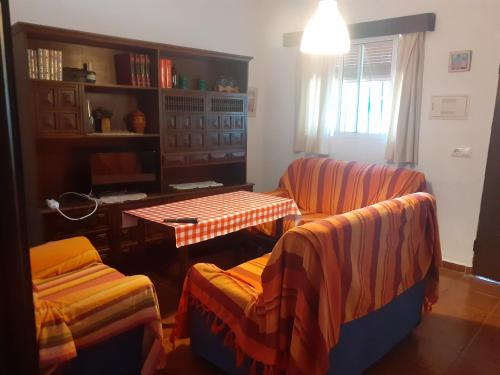 sala de estar con 2 sillas y mesa en Casa Marisa, en Conil de la Frontera