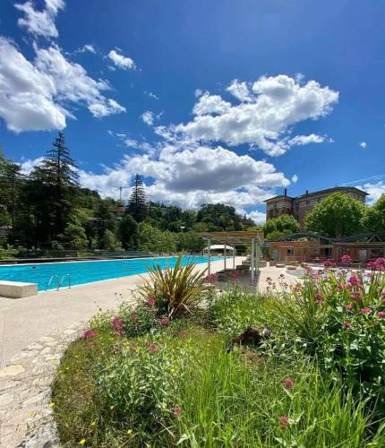 - une grande piscine fleurie dans une cour dans l'établissement T2 Rez-de-chaussée 40 m2 Vals les bains linge de lit et de toilette non fournis, à Vals-les-Bains
