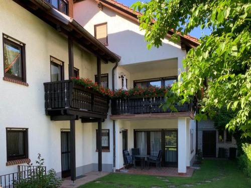 ein Haus mit zwei Balkonen und einem Hof in der Unterkunft Ferienwohnungen im Herzen des Pfälzerwaldes in Elmstein