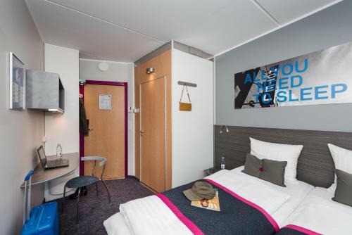 a hotel room with a bed and a desk at Cabinn Odense in Odense