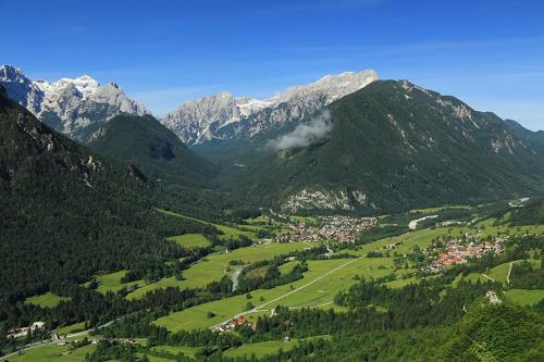 a valley in the mountains with a town and trees at Country house Dovje in Dovje