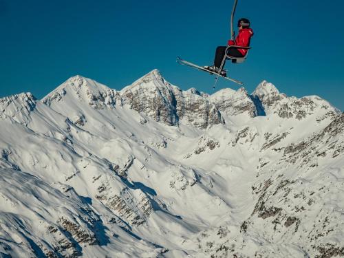 a person in the air on a ski lift over a mountain at Country house Dovje in Dovje