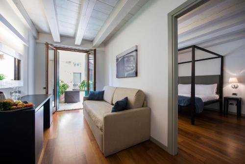 a living room with a couch and a bedroom at Hotel Del Porto in Torri del Benaco