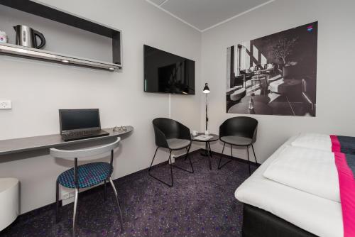 a room with a bed and two chairs and a desk at Cabinn Odense in Odense