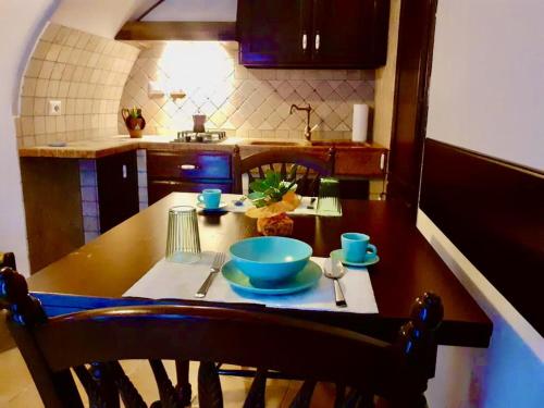 una cocina con una mesa de madera con platos azules. en Casa Graziella, en SantʼAgata di Militello