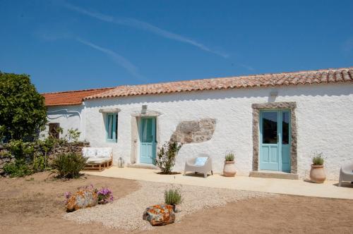 a white and blue house with a blue wall at Massidda Country Retreat in Santa Teresa Gallura