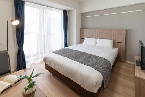 a bedroom with a large bed and a tv at BON Tokyo Asakusa in Tokyo