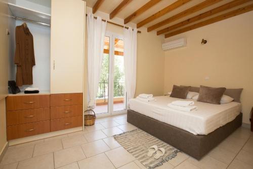 a bedroom with a bed and a large window at Liostasi Retreat in Argostoli