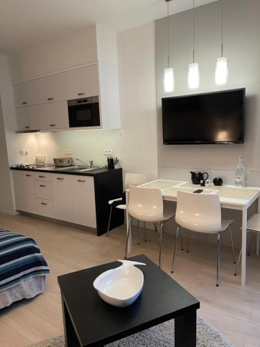 Una sala de estar con una mesa y una cocina. en T&AMarina, en Kąty Rybackie