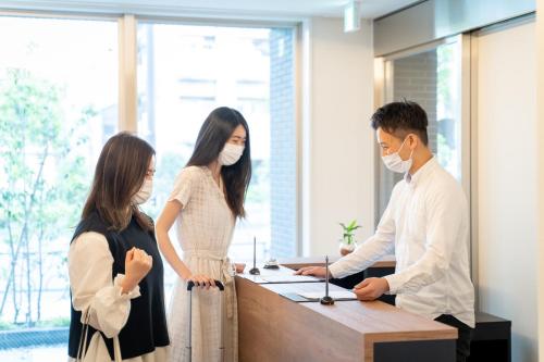 Un groupe de personnes dans un bureau avec des masques dans l'établissement BON Tokyo Asakusa, à Tokyo