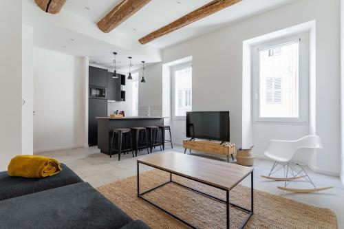 ein Wohnzimmer mit einem Sofa und einem Tisch in der Unterkunft LES PIEDS DANS LE VIEUX PORT in Marseille