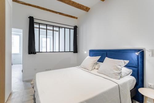 Schlafzimmer mit einem großen Bett mit blauem Kopfteil in der Unterkunft LES PIEDS DANS LE VIEUX PORT in Marseille