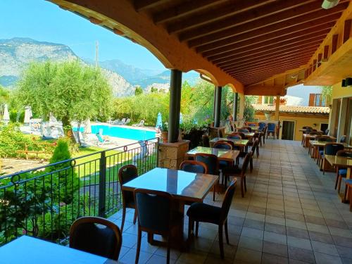 a restaurant with tables and chairs and a swimming pool at Hotel Villa Isabella in Brenzone sul Garda