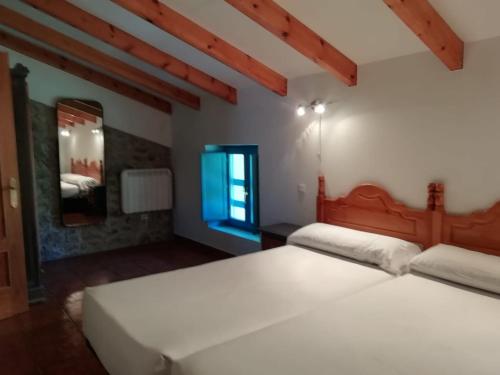 a bedroom with two beds and a window at Casa Pedroso in Noja