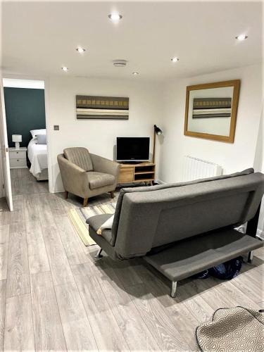 a living room with a couch and a television at Star Apartment Ipswich, A Hidden Gem near the Waterfront in Ipswich