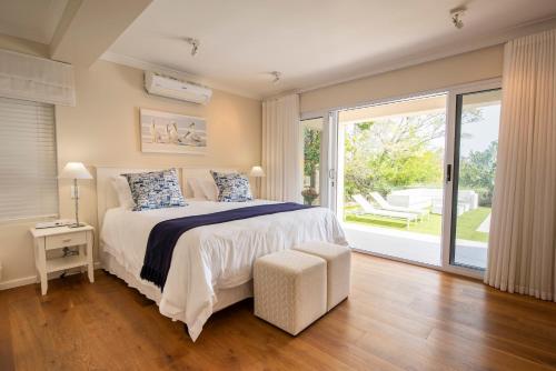 Un dormitorio con una cama y una ventana grande. en Number Eleven Self-Catering Villa, en Knysna