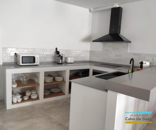 a white kitchen with a sink and a microwave at LA CALILLA II in San José