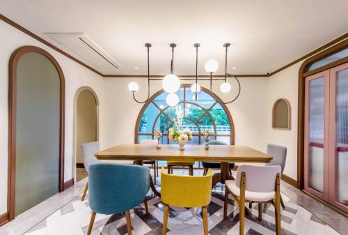 a dining room with a table and chairs with a window at The Cotton Saladaeng Hotel in Bangkok