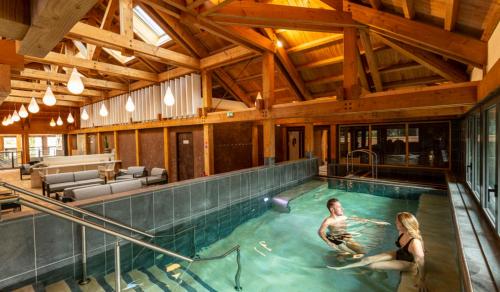 un homme et une femme dans une piscine dans l'établissement Bel Appartement 40 M2 sans linge de lit et de toilette, à Vals-les-Bains