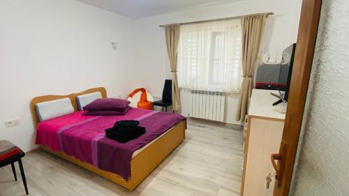 ein Schlafzimmer mit einem Bett mit einer lila Decke in der Unterkunft SunRise Apartament in Mangalia