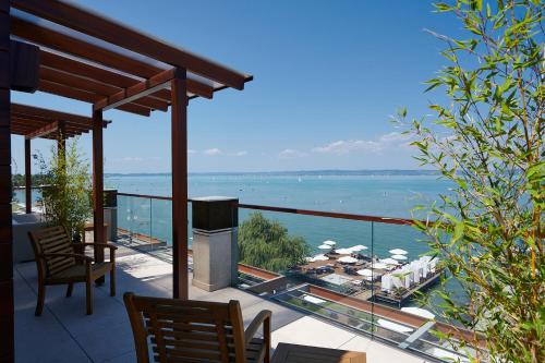 a balcony of a house with a view of the water at Mala Garden Design Hotel in Siófok