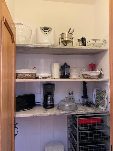a kitchen shelf filled with pots and pans at Lagoa Albufeira House in Sesimbra