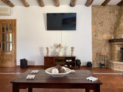 a living room with a table and a tv on a wall at Lagoa Albufeira House in Sesimbra
