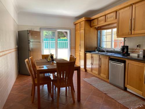 a kitchen with a table and chairs and a refrigerator at Lagoa Albufeira House in Sesimbra