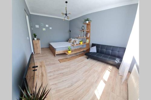 a living room with a bed and a couch at The sunny willow apartments in Liepāja