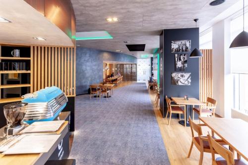 a dining room with tables and chairs and a room with a unintention at STEELHOUSE Hotel in Třinec