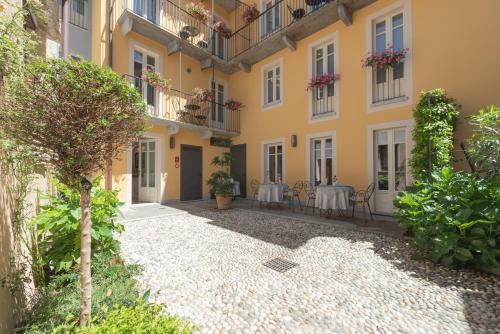 een binnenplaats van een gebouw met tafels en stoelen bij Antico Borgo B&B in Cannobio