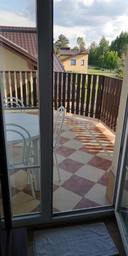 a sliding glass door with a chair on a patio at Agroturystyka Relaks in Orzeszkowo