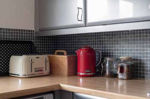 a kitchen counter with a red appliance on a counter top at Putney Perfection in London