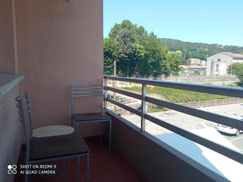 balkon z krzesłem i widokiem na ulicę w obiekcie Ecorooms PADRÓN w mieście Padrón