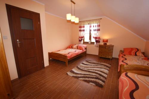 a small bedroom with two beds and a door at Apartamenty przy basenie blisko morza Brown in Puck