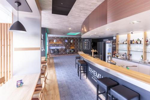 a bar in a restaurant with chairs and a counter at STEELHOUSE Hotel in Třinec