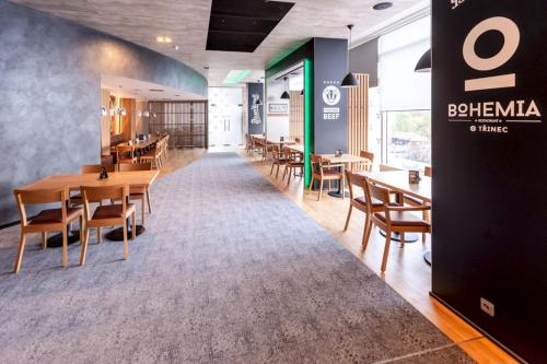a dining room with wooden tables and chairs at STEELHOUSE Hotel in Třinec