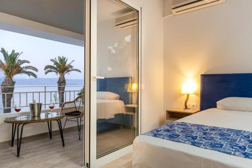 a bedroom with a bed and a view of the ocean at Sirocco Hotel in Kavos