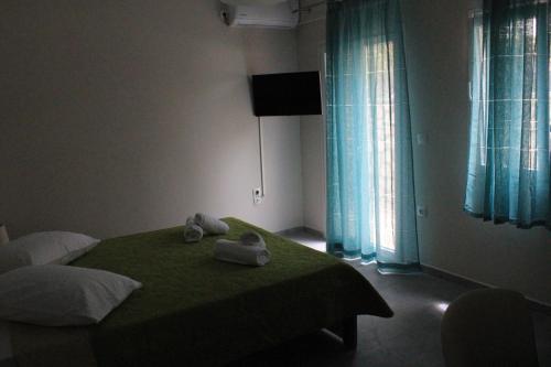 a bedroom with a green bed with towels on it at Chloe Apartments in Tsoukaladhes