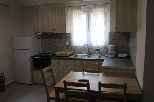 a kitchen with a table and chairs and a sink at Chloe Apartments in Tsoukaladhes