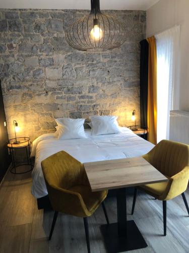 a bedroom with a bed and a stone wall at Le Durbuysien in Durbuy