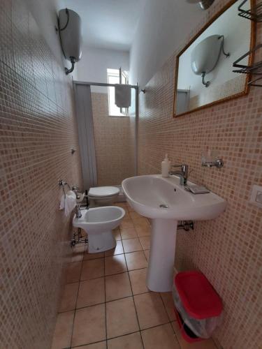 a bathroom with a sink and a toilet and a mirror at Osteria B&B Il Rifugio in Peschici