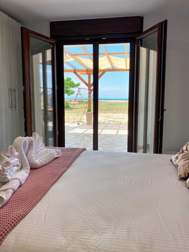 a bedroom with a bed with a view of the ocean at Seafront Oasis Beach Houses in Ierissos