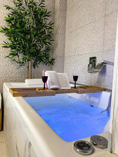 a bath tub with a table and two glasses of wine at Seafront Oasis Beach Houses in Ierissos