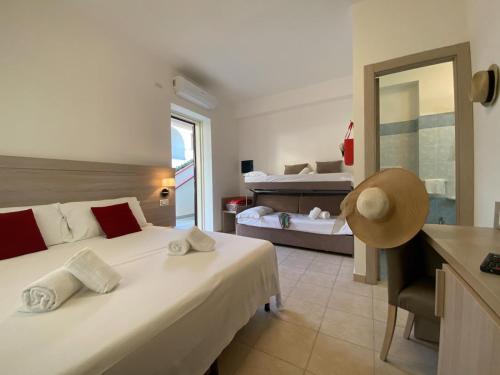 - une chambre avec un grand lit et un miroir dans l'établissement Primavera Club - Hotel Residence, à Santa Maria del Cedro