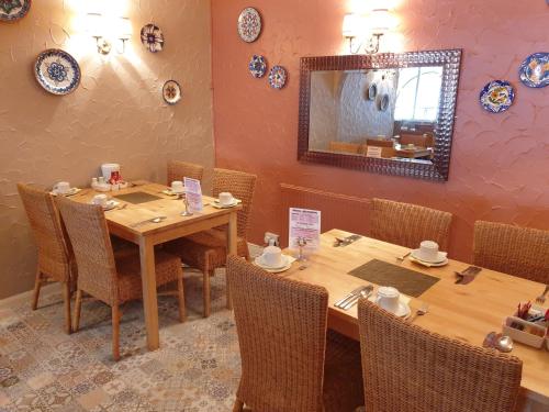 a dining room with wooden tables and chairs and a mirror at Corona Blackpool in Blackpool