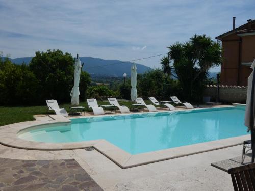 une grande piscine avec des chaises longues et une montagne dans l'établissement I Due Melograni Agriresort, à Tarano